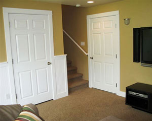 The new doors to a storage room and the garage match the ones upstairs, and the beadboard wainscot runs on two walls, echoing the design of the cabinet