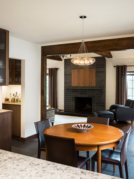 Cladding the openings with natural wood to match the look of the living room beams provides linkage from one room to the next and is an organic counterpoint to the primarily contemporary finishes