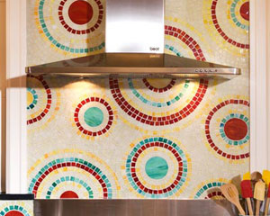 The star of the show is the hand-cut mosaic glass tile, designed and crafted by one of the owners.  The swirls of color compliment the multi-colored cabinets, custom kitchen tile backsplash