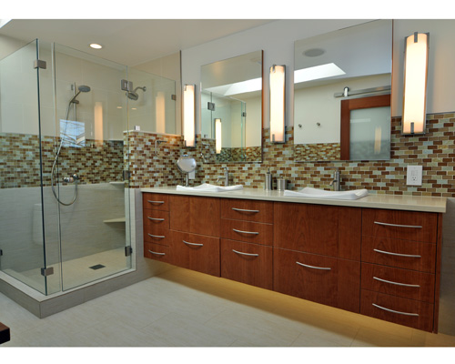 The new floating cherry cabinets with tape lighting below help create a luxurious feel.  By using lots of tile and glass, the floor plan is now completely open. Seattle award winning remodeler