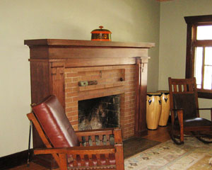 The living room had been dark, with large bookshelves flanking the fireplace.  A new mantle with Craftsman detailing is made from quarter-sawn oak.  It brings a whole new feeling to this room while keeping the original fireplace facade