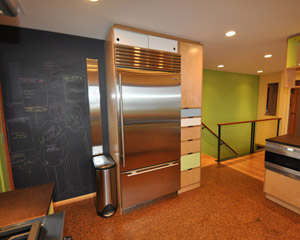 The door to the side yard is relocated into the corner, leaving an open wall for a message center and plenty of space for the Subzero fridge and floor-to-ceiling pantry storage